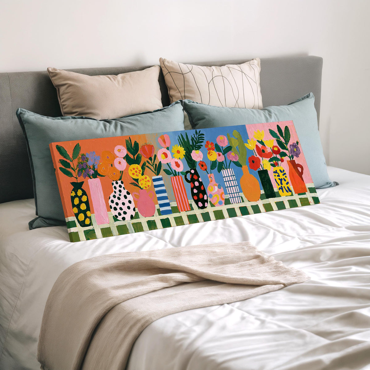 Patterned vases with bright bouquets wide panoramic canvas print laid on a bed to show its size