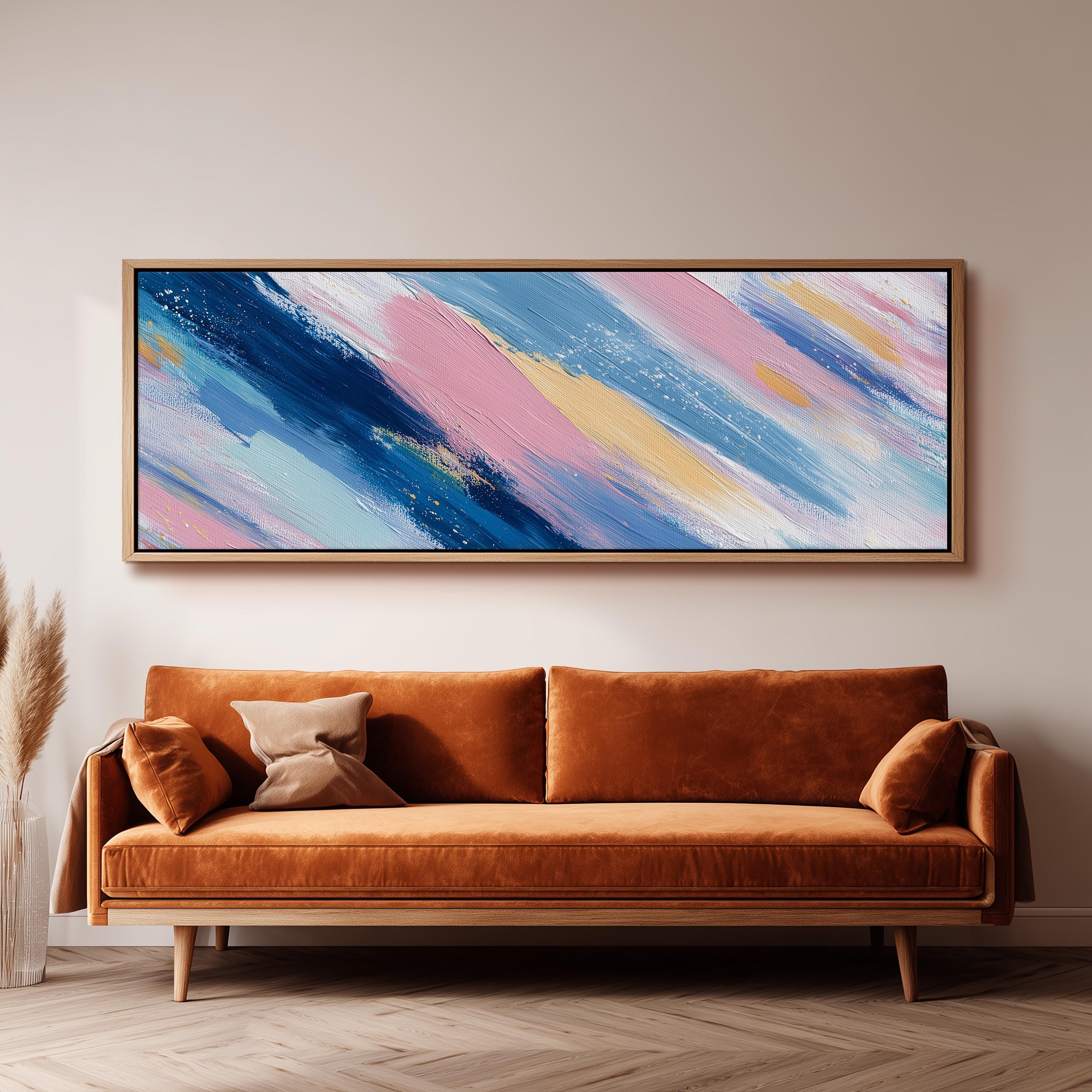 a large abstract painting hanging on a wall above a brown sofa with two pillows.