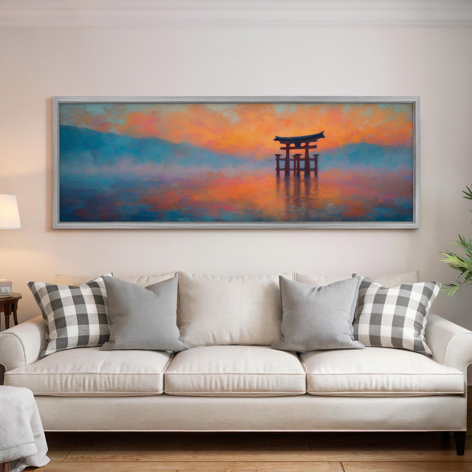 a large painting of a torii gate in a serene landscape, hanging on a wall above a white sofa with gray and white patterned pillows.