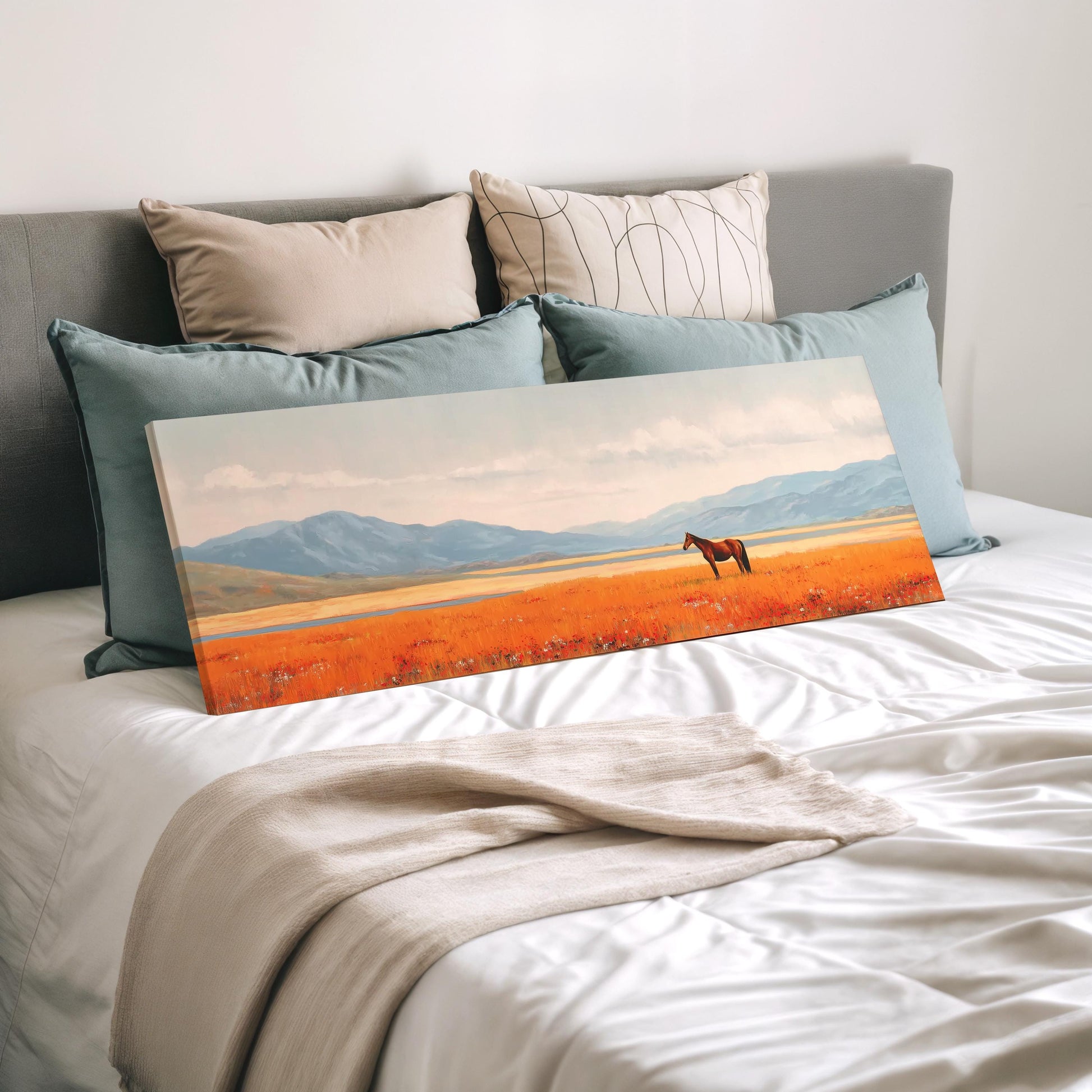 a large canvas print of a horse in a field, with mountains in the background.