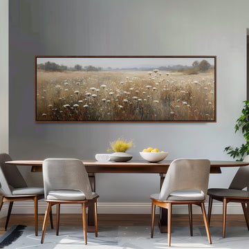 a dining room with a large painting of a field of flowers hanging on the wall above a wooden dining table with four chairs. The table is set with a bowl of fruit and a vase of flowers, creating a cozy and inviting atmosphere.