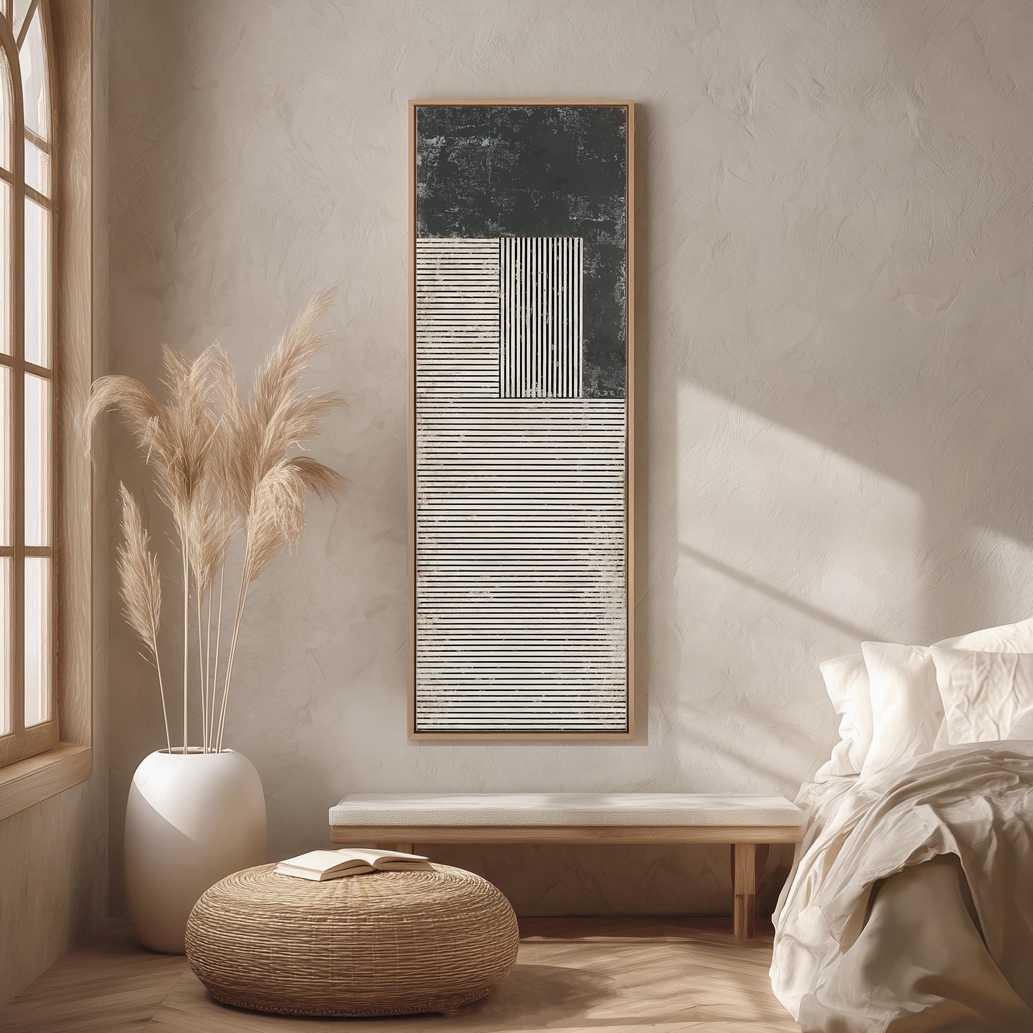 a serene and minimalist bedroom with a large window, a white bed, a wooden bench, a woven ottoman, and a framed abstract artwork on the wall.