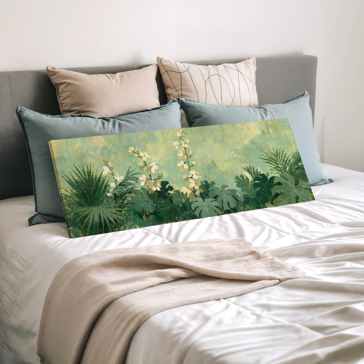 Tropical white blooms in green foliage wide panoramic canvas print laid on a bed to show its size